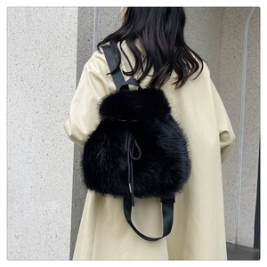 Detail view of the plush black faux fur texture and drawstring on a stylish backpack