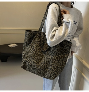 Detailed view of leopard print canvas tote bag on model for size and style reference