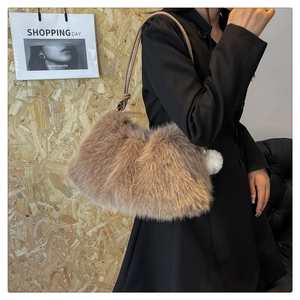 Detail of plush shoulder bag in dark latte with soft faux fur and pompom charm