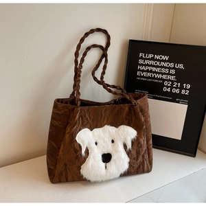 Close-up of brown quilted tote bag featuring a white plush puppy patch and rope handles