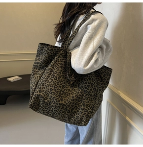 Fashionable leopard print canvas tote bag shown worn by a model in a minimalist setting