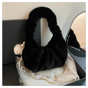 Detail of black faux fur crescent bag with gold chain strap and pearl charm accent
