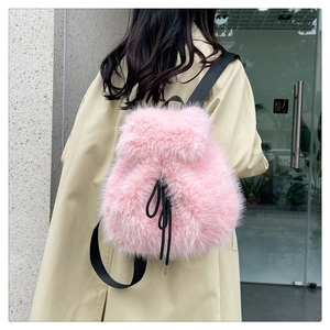 Close-up of pink faux fur backpack featuring black adjustable straps and drawstring detail