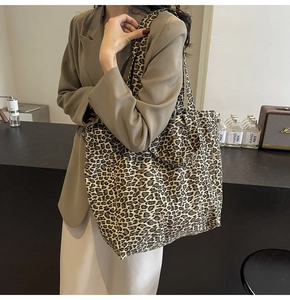 Detail of large capacity leopard print canvas tote bag in a stylish cafe setting