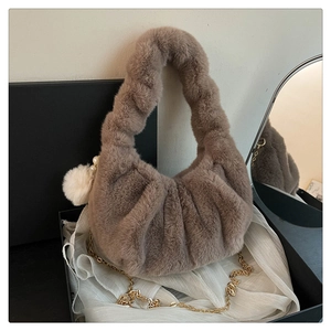 Detail of plush dumpling bag with faux fur texture, pearl charm and gold chain strap