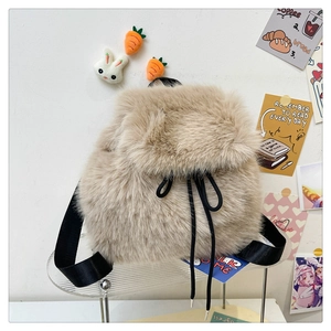 Detail of plush beige backpack showing soft faux fur texture and cute rabbit charms