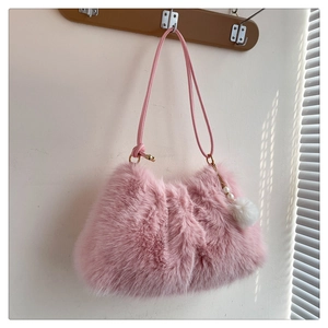 Detailed texture of pink faux fur shoulder bag with pearl and pompom charm detail