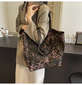 Detail of large leopard print canvas tote bag styled with a brown blazer for casual look