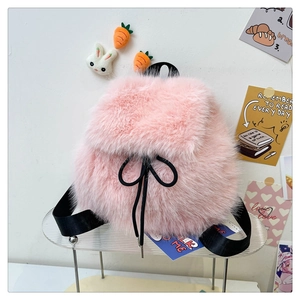 Detailed view of pink faux fur drawstring backpack with black straps and soft texture