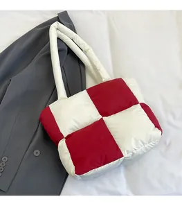 Detail of red and white checkered puffer tote bag with quilted padding on blazer background