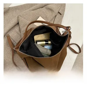 Detailed interior of large brown matte leather tote showing spacious storage for essentials