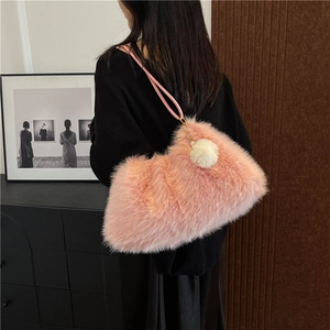 Chic pink faux fur tote bag with plush pom-pom detail shown on a female model