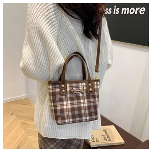 Detail of wool plaid handbag with puppy embroidery and premium leather handles