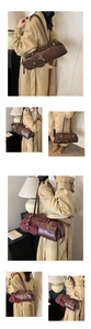 Detail of dark brown leather baguette bag with red lining and matching small pouch
