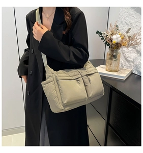 Détail du sac messager en nylon vert clair avec doubles poches zippées et compartiments