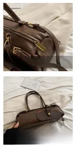 Detailed macro view of gold zipper and lychee texture on dark brown leather baguette bag