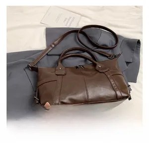 Detail view of dark brown vintage tote bag with double handles and adjustable shoulder strap