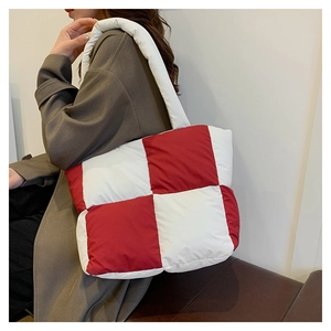Detailed view of red and white checkered puffer tote bag with quilted texture and soft fabric