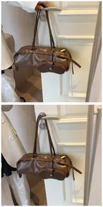 Detail of dark brown vintage Boston bag with leather texture and bronze buckles
