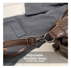 Detail of adjustable shoulder strap with silver metal buckle on a brown tote bag