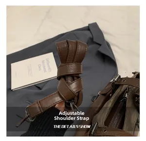 Detail view of the adjustable brown PU leather shoulder strap with dark matte metal hooks