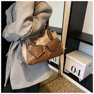 Detail of vintage tote bag with mixed canvas and PU leather panels and functional pockets