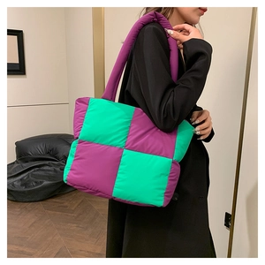Detail of checkered quilted nylon tote bag with purple and green contrast blocks
