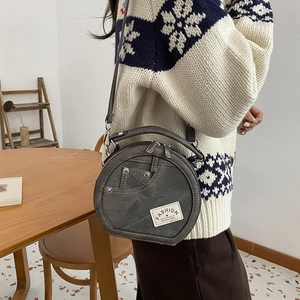 Vintage gray circular crossbody bag with denim pocket design and fashion label detail