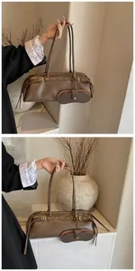 Detail of dark brown baguette bag with dual slim straps and removable crescent pouch