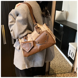 Detail view of vintage brown patchwork tote bag with multi-pocket design on model
