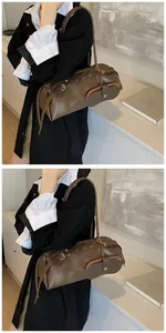 Detail of a brown cylinder baguette bag with a side pocket and adjustable shoulder strap