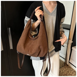 Detailed view of dark brown suede hobo bag with adjustable strap and vintage texture