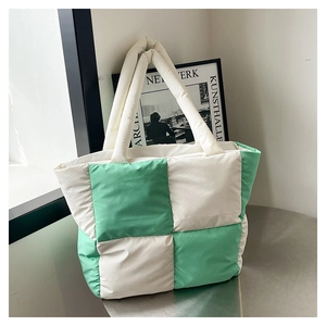 Detailed shot of green and white checkerboard quilted tote bag on a modern table