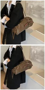 Detail view of a vintage dark brown leather boston bag with adjustable straps and coin purse