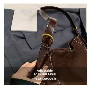 Adjustable shoulder strap of a brown matte PU saddle bag with white stitching details