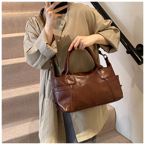 Detail of dark brown vintage underarm bag with glossy leather texture on a staircase