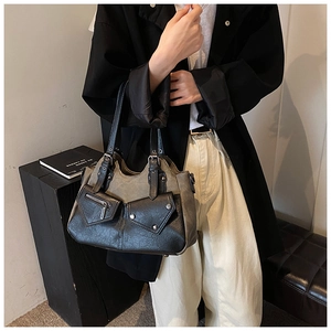 Detail of vintage large capacity leather tote with asymmetrical pockets and rivet accents