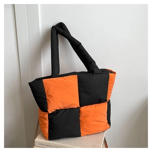 Detailed close-up of puffy quilted tote bag with orange and black color block design