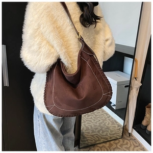 Detail of vintage brown suede tote with white contrast stitching and woven edge
