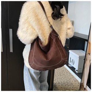 Detailed view of brown matte suede tote with braided edge and bohemian stitching details