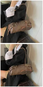 Detail of a dark brown baguette bag with leather stitching and decorative buckles