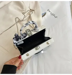 Top view of PVC camera-shaped bag interior with silver metal chain and scarf handle
