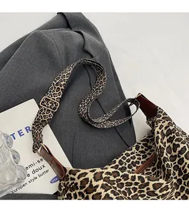 Detail of leopard print tote bag featuring metallic adjustment buckle and fabric texture