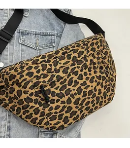 Detailed close-up of leopard print crossbody bag on denim jacket highlighting canvas texture