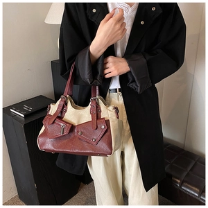 Detail of vintage canvas and leather tote bag featuring multiple pockets and silver hardware