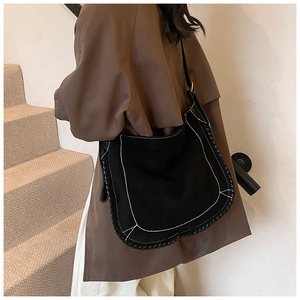 Close-up of black matte tote bag with contrast white stitching and woven edge detailing