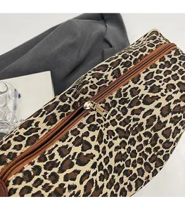 Close-up of smooth brown zipper with gold metal puller on leopard print tote bag