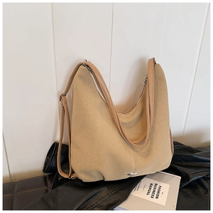 Detail view of khaki canvas tote with pleated design and silver metal oval buckle ornament