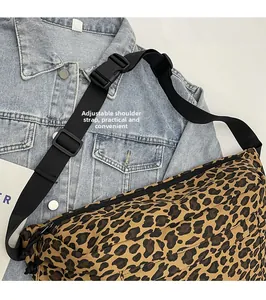 Detail view of the adjustable black nylon strap and buckle on leopard print fanny pack