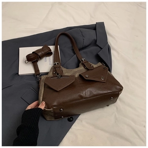 Detail of vintage tote bag featuring brown leather and canvas patchwork with strap